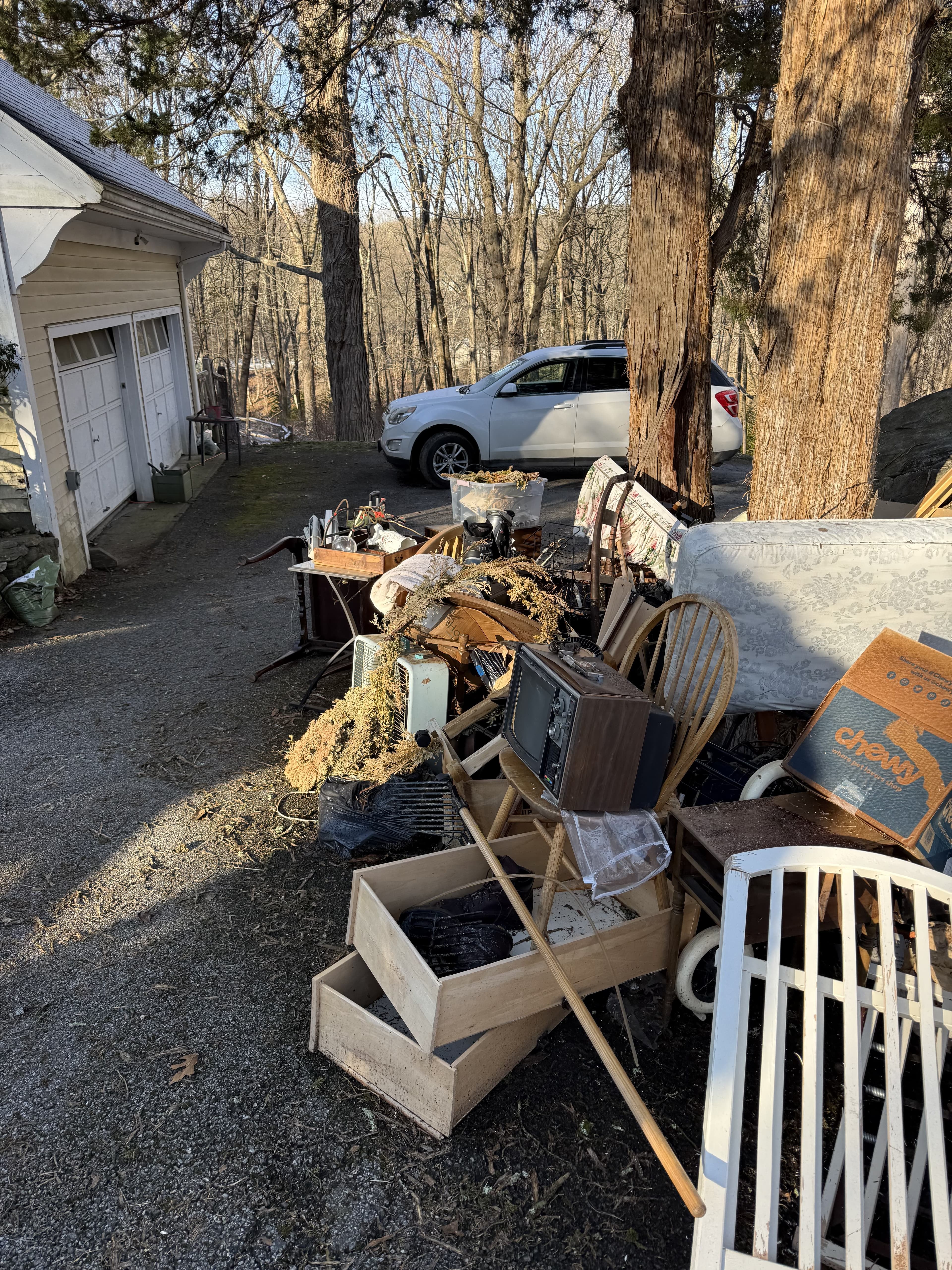 Household contents piled outside a garage during a whole-home cleanout